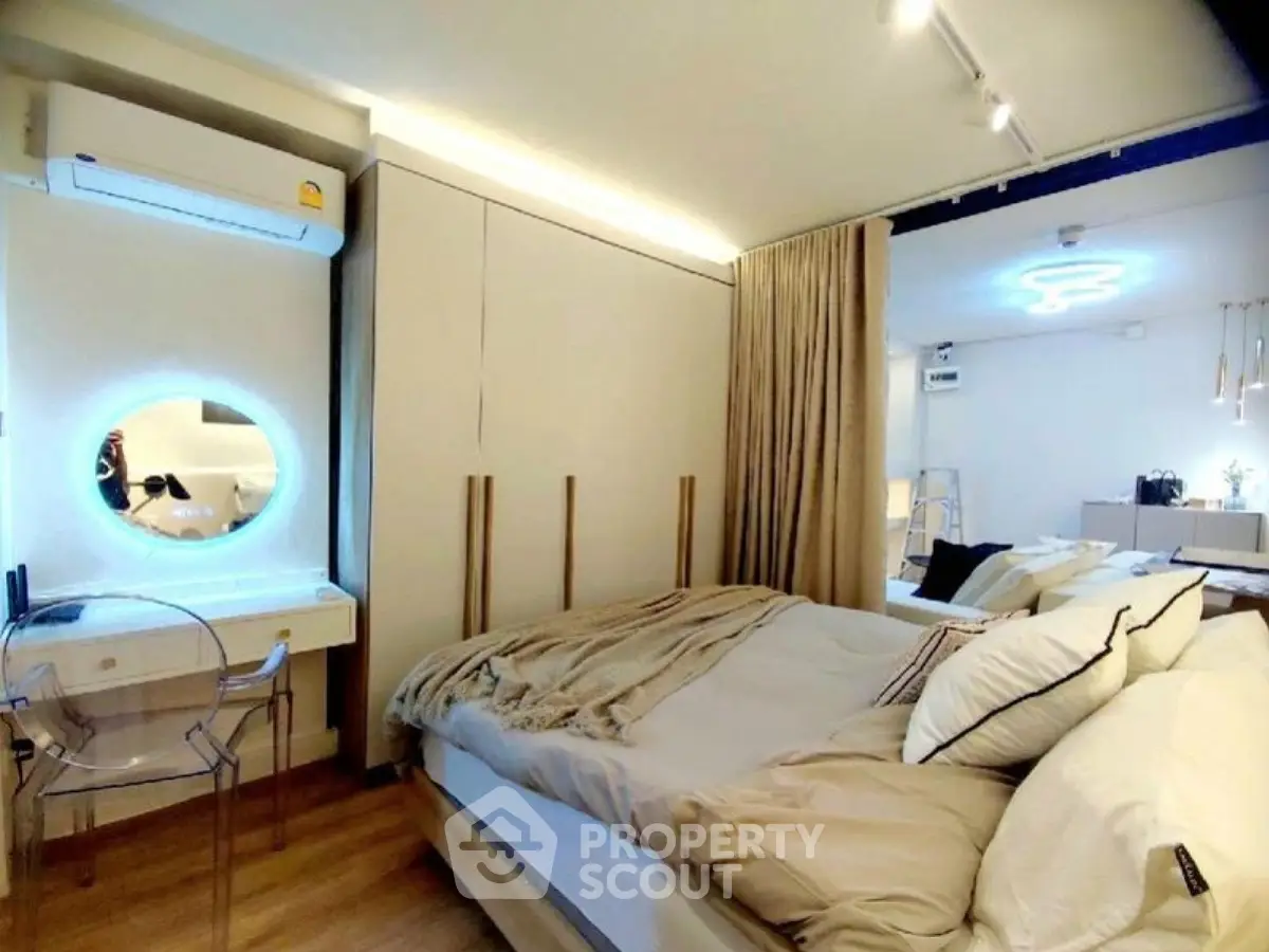 Modern bedroom with stylish decor and cozy ambiance, featuring a chic vanity and ambient lighting.