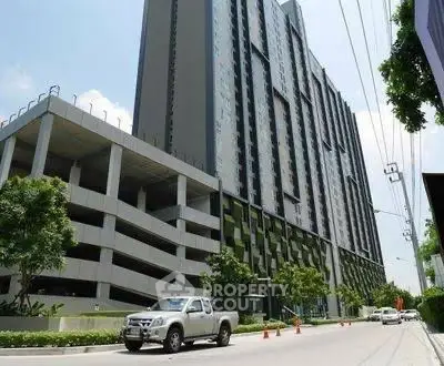 Modern high-rise building with parking structure and street view