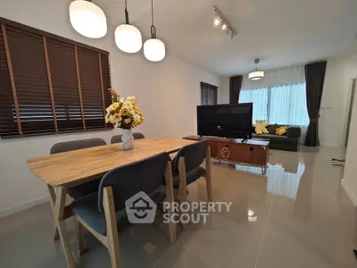 Modern living room with dining area, stylish furniture, and elegant lighting.