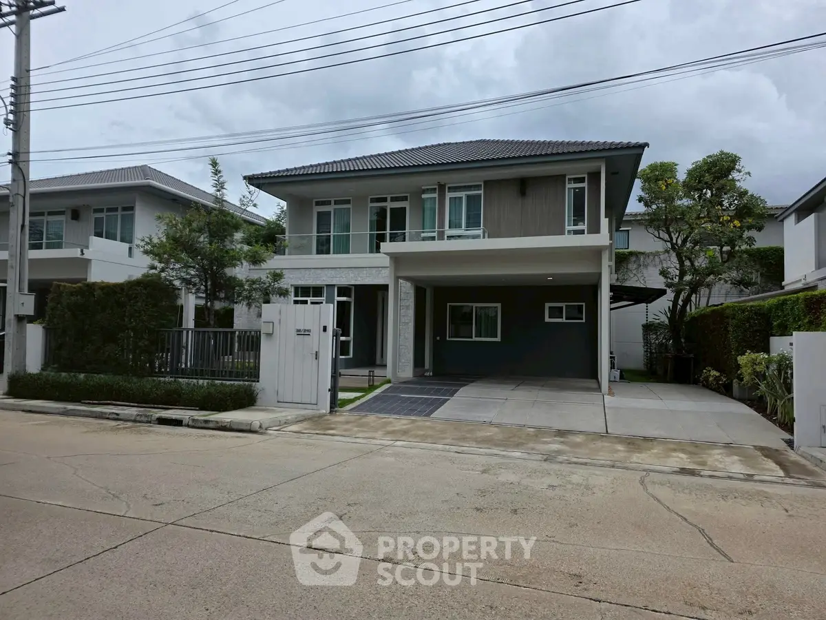 Modern two-story house with spacious driveway and lush greenery