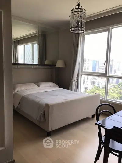Elegant bedroom with city view, featuring large windows and stylish decor.
