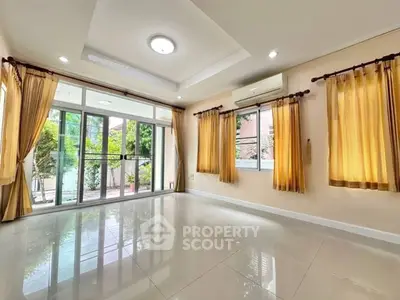 Spacious living room with large windows and garden view, perfect for natural light lovers.