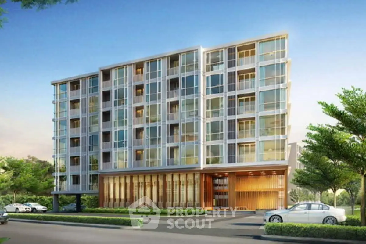 Modern apartment building with sleek glass facade and lush landscaping.