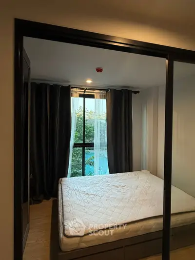 Cozy bedroom with large window and garden view, featuring modern decor and ample natural light.