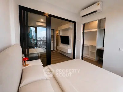 Modern bedroom with city view, featuring a cozy bed, glass partition, and wall-mounted TV.
