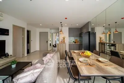 Modern open-plan living room and kitchen with stylish decor and dining area.