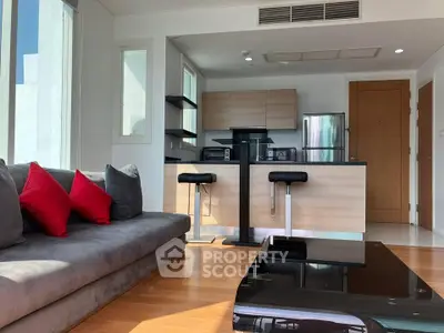 Modern open-layout living room with sleek kitchen and stylish furniture in a bright apartment.