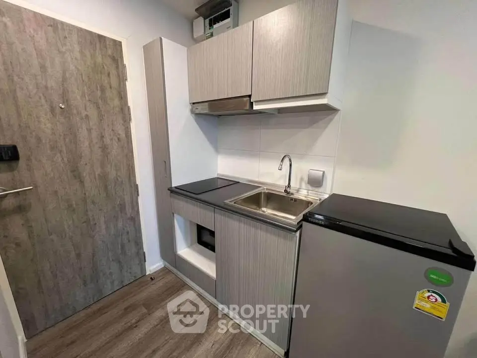 Compact modern kitchen with sleek cabinetry and stainless steel appliances