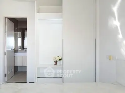 Modern minimalist bedroom with ensuite bathroom and sleek white decor