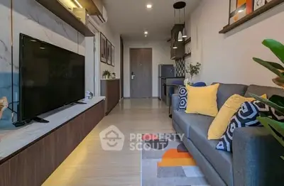 Modern living room with stylish decor and open layout, featuring a cozy sofa and large TV.