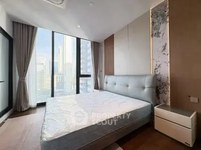 Luxurious bedroom with floor-to-ceiling windows and city view in modern apartment