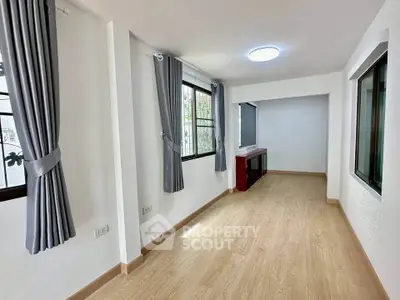 Spacious and bright living room with large windows and elegant curtains, perfect for modern living.