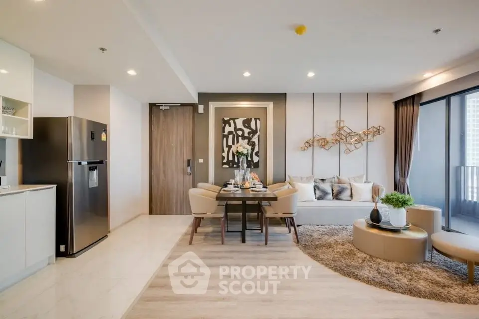 Modern open-plan living room with stylish decor and dining area, featuring elegant furniture and natural light.
