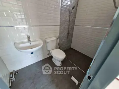 Modern bathroom with sleek white tiles and walk-in shower design.