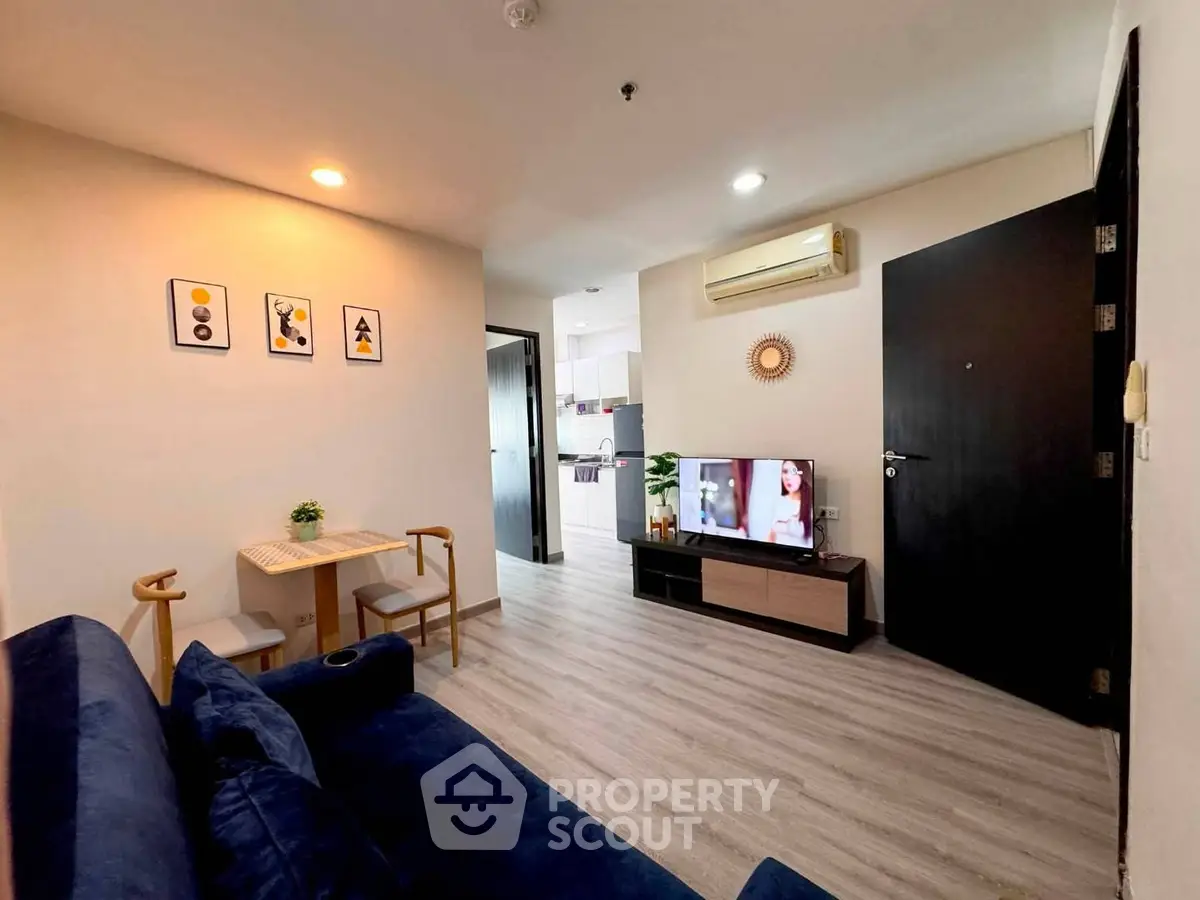Modern living room with stylish decor and open layout, featuring a cozy sofa and wall-mounted TV.