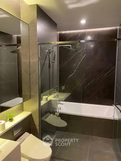 Luxurious modern bathroom with sleek glass shower and elegant dark tiles