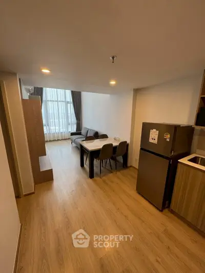 Modern living room with dining area and kitchen in open layout apartment.