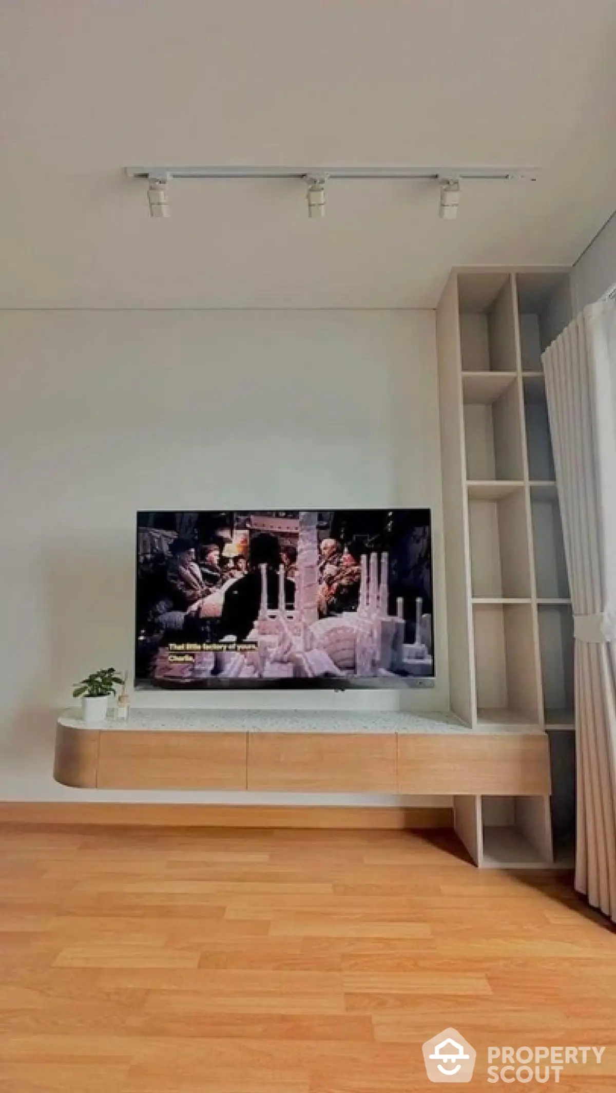 Modern living room with sleek TV unit and wooden flooring