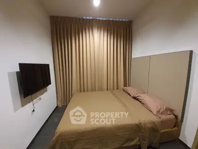 Cozy bedroom with modern decor and wall-mounted TV, perfect for relaxation.
