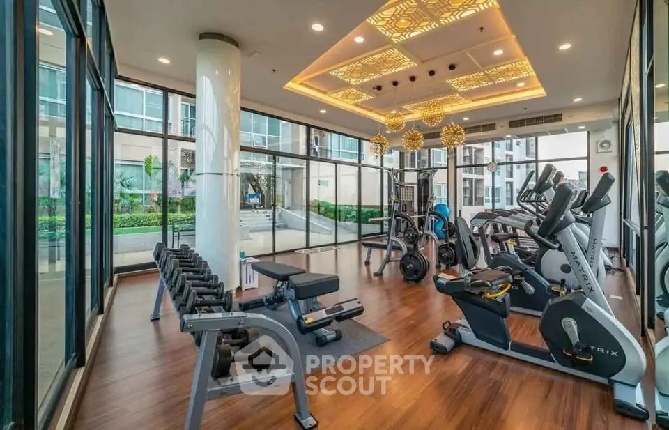 Modern gym with state-of-the-art equipment and stylish lighting in a luxury residential building.