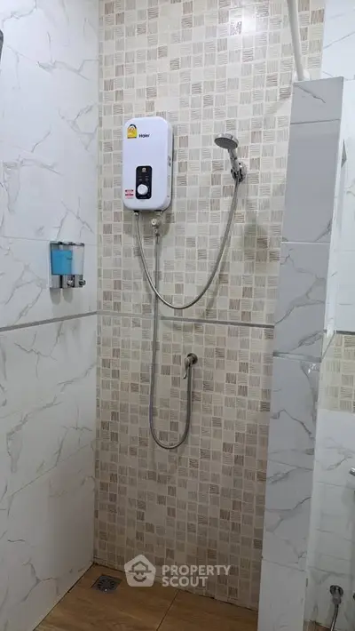 Modern bathroom with stylish shower and water heater, featuring elegant tile design.