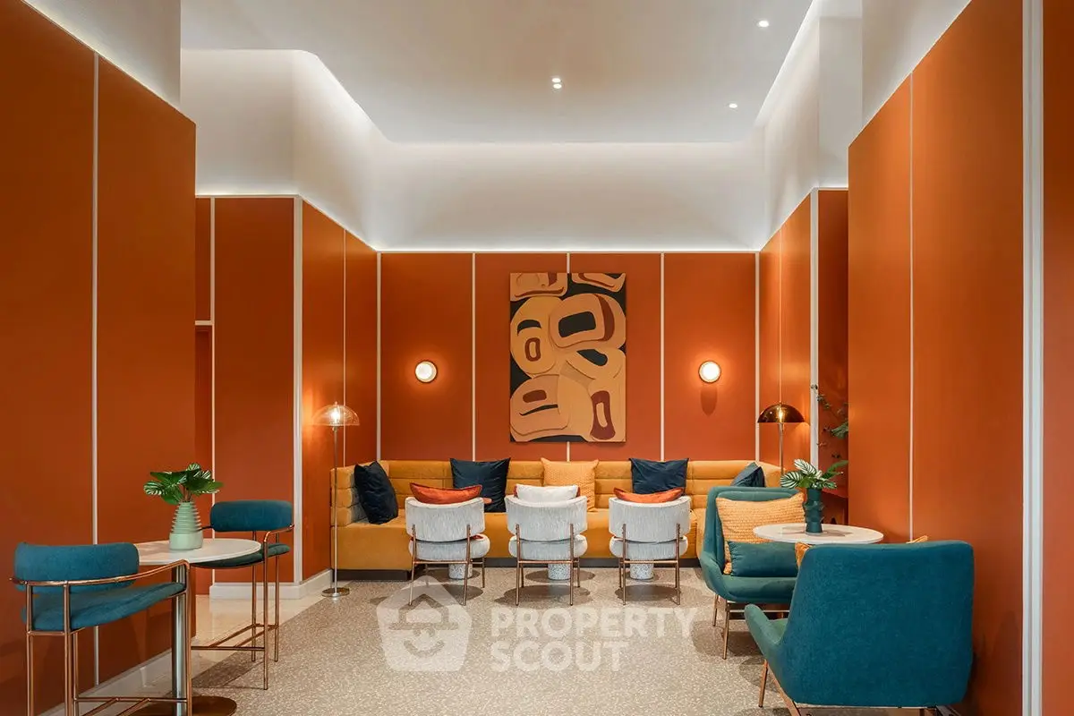 Stylish modern living room with vibrant orange walls and chic seating arrangement.