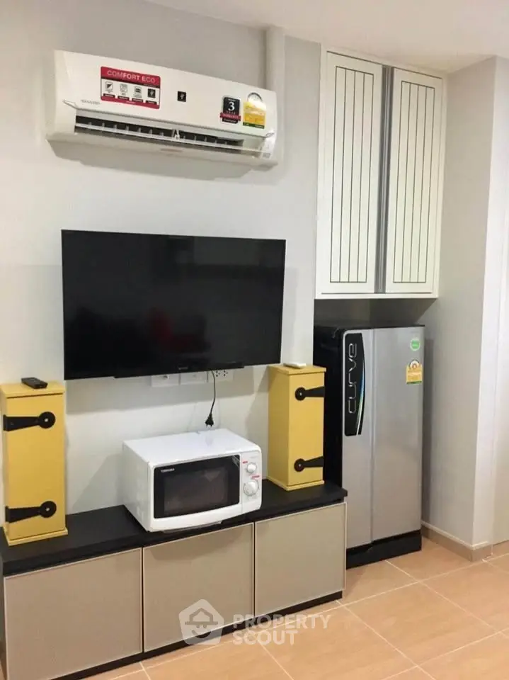 Modern living room with air conditioner, TV, and appliances