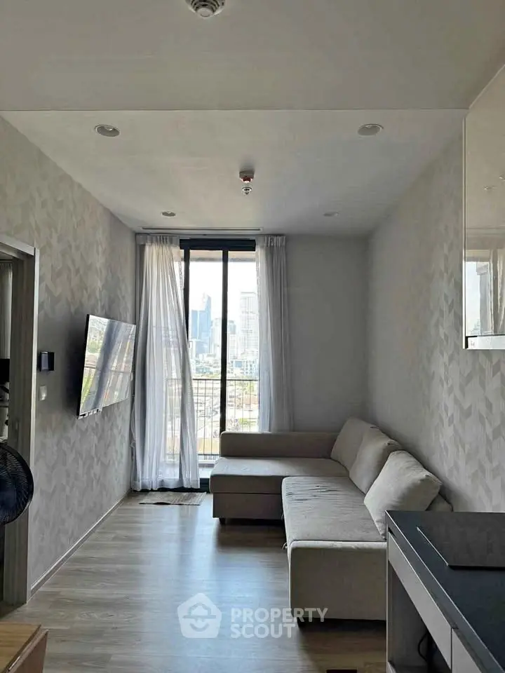 Modern living room with city view, featuring sleek furniture and large windows for natural light.