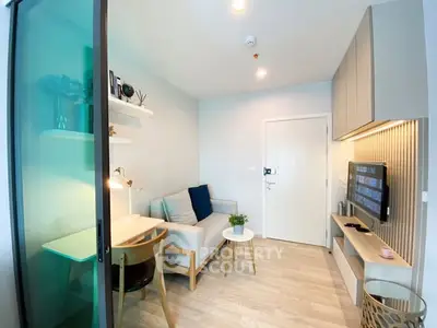 Modern living room with stylish decor and cozy seating area in a compact apartment.