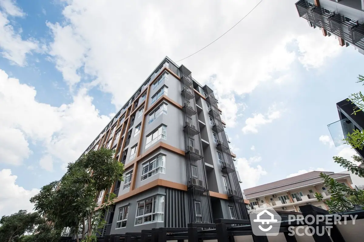 Modern multi-story residential building with a striking facade, showcasing a blend of contemporary design and urban architecture against a clear sky.