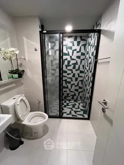 Modern bathroom with geometric tile shower and sleek fixtures