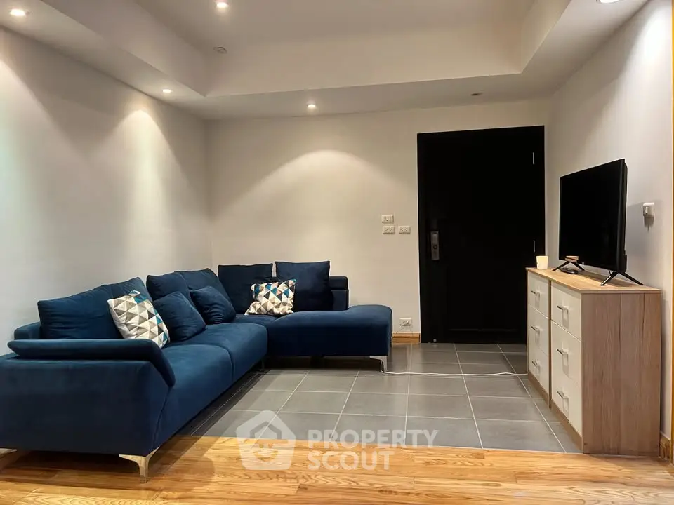 Modern living room with stylish blue sofa and sleek TV setup