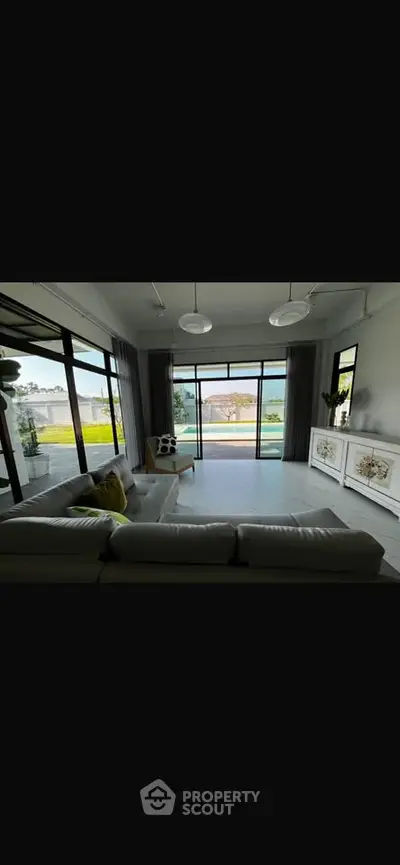 Spacious living room with large windows and scenic view, modern decor and ample natural light.