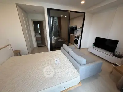 Modern studio apartment with open layout, featuring a cozy living area, kitchen, and bedroom with a view.