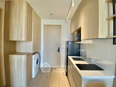 Modern kitchen with sleek appliances and wooden cabinetry in a compact layout.