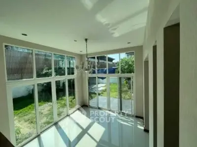 Spacious sunlit room with large windows and garden view