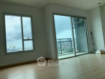 Spacious apartment with large windows and balcony offering stunning city views.