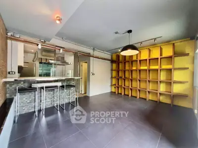 Modern open-plan living room with stylish kitchen and unique shelving
