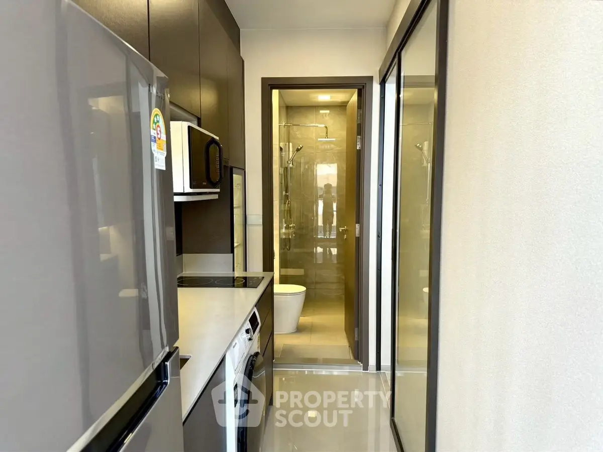 Modern compact kitchen with sleek appliances and glossy flooring