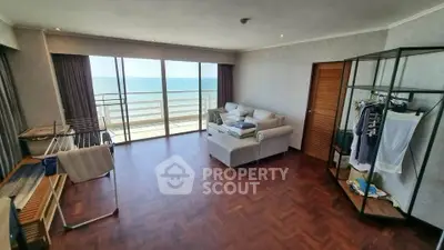 Spacious living room with ocean view and balcony access, featuring modern decor and hardwood floors.