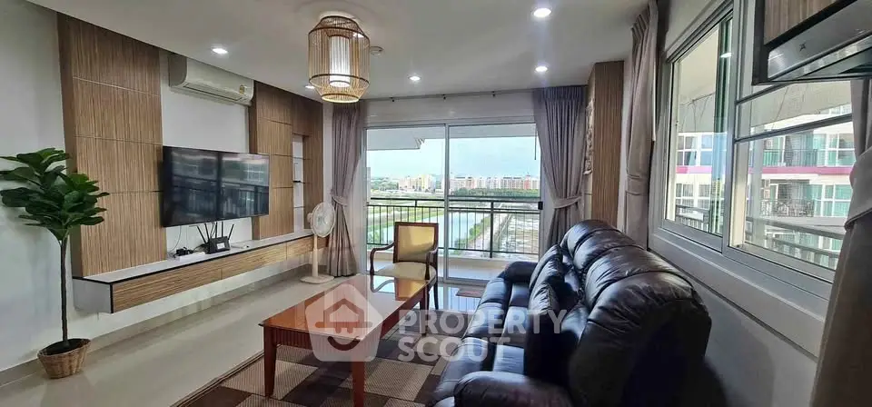 Spacious living room with modern decor and large windows offering a stunning city view.