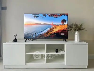 Modern living room with sleek TV stand and flat-screen TV, perfect for entertainment.