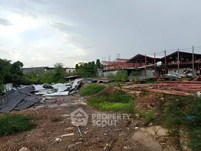 Vacant industrial land with construction materials and structures under development.