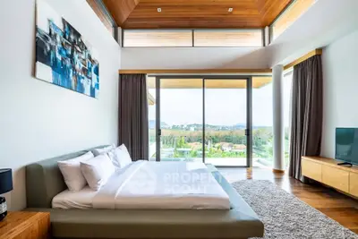 Luxurious bedroom with panoramic view and modern decor in a high-end property.