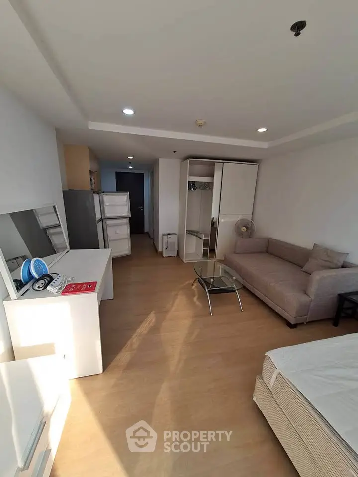 Spacious living room with modern furniture and ample natural light in a stylish apartment.