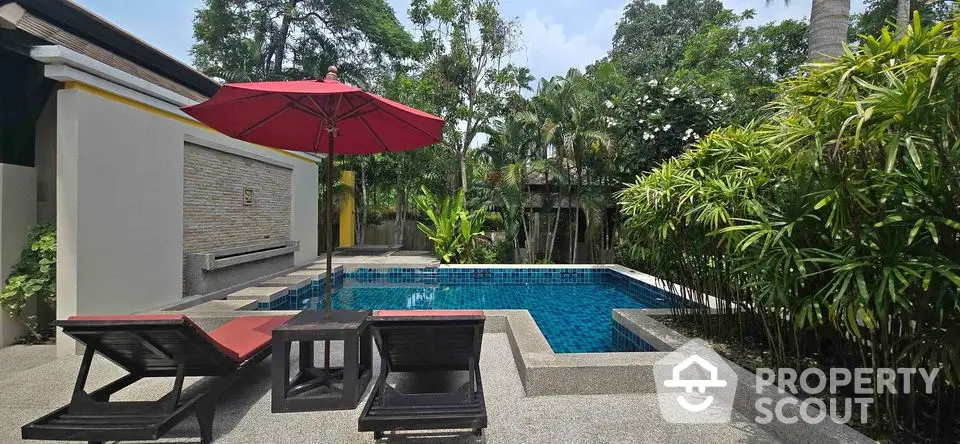 Luxurious private pool area with lush greenery and stylish sun loungers, perfect for relaxation and entertainment.