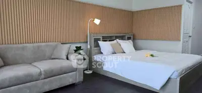 Modern bedroom with stylish decor and cozy couch, perfect for relaxation.