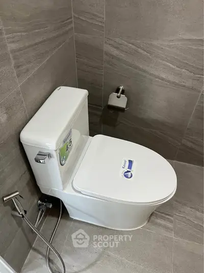 Modern bathroom with sleek toilet and gray tiled walls