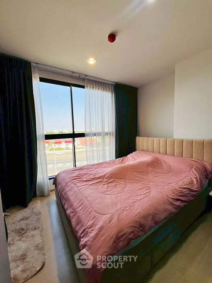 Cozy bedroom with large window and stylish decor in modern apartment