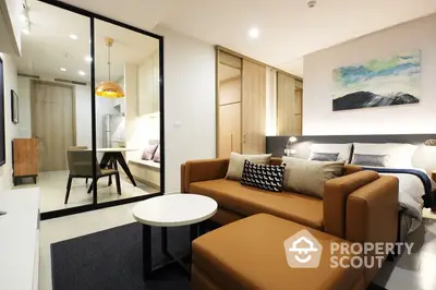 Chic modern studio with integrated living and sleeping areas, featuring sleek furniture, a cozy bed nook, and a compact yet functional workspace.